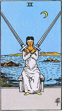 The Two of Swords tarot card: a blindfolded woman by the sea holding two crossed swords
