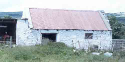 A whitewashed stone farmhouse with a red roof