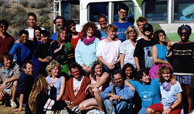 A large group of passengers posing together in front of the bus