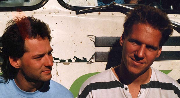 Drivers Brian and Geoff, smiling, in front of the bus
