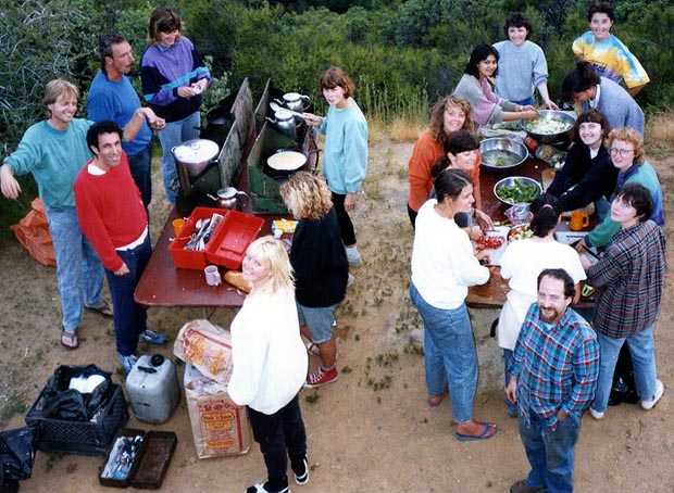 Passengers gathered around tables of food, seen from above